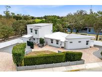 Stylish modern home with a geometric design, white exterior, brick driveway, and manicured front yard hedge at 720 N Pennsylvania Ave, Winter Park, FL 32789