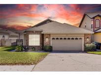Charming single Gathering home featuring a brick facade, manicured lawn, and two-car garage at 7244 Somersworth Dr, Orlando, FL 32835
