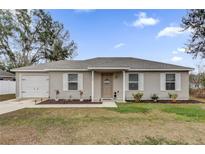 Charming single-story home with manicured lawn, a front-facing garage and inviting front porch at 10 Pine Course Pass, Ocala, FL 34472