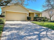 Charming single-story home featuring a well-manicured lawn and a brick paved driveway at 1107 Galway Blvd, Apopka, FL 32703