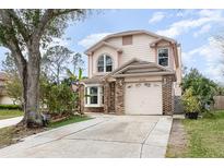 Charming two-story home with a brick-accented facade and well-maintained front yard, offering a welcoming curb appeal at 12100 Calaboose Ct, Orlando, FL 32828