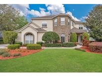 Charming two-story home featuring a manicured lawn and complemented by tasteful landscaping and brick accents at 1601 Billingshurst Ct, Orlando, FL 32825