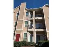 Three story condo building featuring multiple balconies and tan siding at 2000 Erving Cir # 102, Ocoee, FL 34761