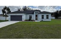 Charming single-story home featuring a well-manicured lawn and a two-car garage at 2662 Sw 152Nd Ln, Ocala, FL 34473