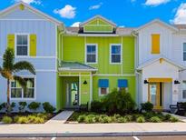 Colorful townhomes with manicured landscaping, lush greenery, and vibrant architectural details at 2927 Castaway Ln, Kissimmee, FL 34747