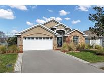 Charming single Gathering home featuring stone accents, a two-car garage and beautiful landscaping at 4057 Sunny Day Way, Kissimmee, FL 34744