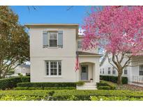 Charming two-story home featuring light stucco exterior and a blooming pink tree in the front yard at 5238 Baskin St, Orlando, FL 32814