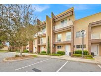 Modern townhome exterior featuring a three-story facade, balcony, manicured landscaping, and convenient parking at 7661 Recife Dr, Kissimmee, FL 34747