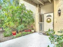 Inviting front entrance features a white door with a sunflower wreath and is surrounded by lush greenery at 102 Tomoka Trl # 102, Longwood, FL 32779