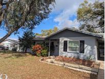 Charming single-story home featuring neutral paint, complimented by mature trees and a well-manicured front yard at 103 Brown Dr, Sanford, FL 32773