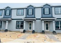 Modern townhome exterior showcases contemporary design, gray siding, and well-lit doorways at 15352 Burgtheater Dr, Winter Garden, FL 34787