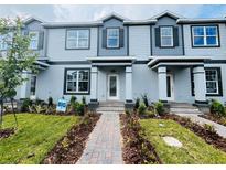 Charming light blue townhome exterior featuring well-manicured landscaping and a welcoming entryway at 15352 Burgtheater Dr, Winter Garden, FL 34787