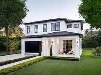 Beautiful two-story home featuring a manicured lawn, black framed windows, and a covered front porch with seating area at 1917 Geigel Ave, Orlando, FL 32806