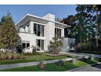 Stunning modern two-story home with large windows, crisp white exterior, and meticulously landscaped front yard at 229 Alexander Pl, Winter Park, FL 32789