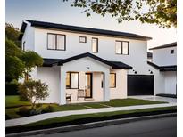 Striking two-story modern home with a black roof, minimalist landscaping, and a two-car garage at 25 S Graham Ave, Orlando, FL 32803