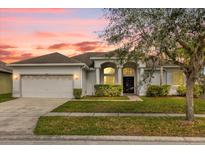 Charming one-story home with a manicured lawn, arched entryway, and two-car garage at 2819 Boating Blvd, Kissimmee, FL 34746