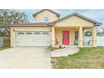 Charming two-story home featuring a bright red front door and attached garage at 410 S Hudson St, Orlando, FL 32835