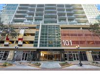 Modern condo building exterior with large windows, balconies, and street-level retail space at 101 S Eola Dr # 1001, Orlando, FL 32801