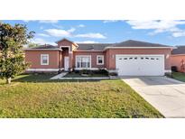 Charming single-story home with a well-manicured lawn and attached two car garage at 372 Aylesbury Ct, Kissimmee, FL 34758