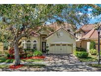 Charming home with a tile roof, well-maintained landscaping, and a brick driveway at 6992 Brescia Way, Orlando, FL 32819