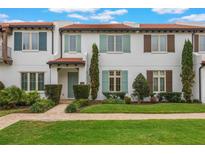 Charming townhome featuring a red tile roof, colorful shutters, and manicured landscaping at 8742 European Fan Palm Aly, Winter Garden, FL 34787