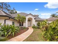 Charming home exterior with lush landscaping and a welcoming entryway, and tile roof at 9308 Thurloe Pl, Orlando, FL 32827