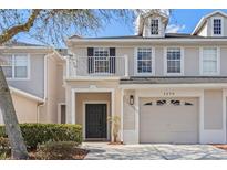 Charming two-story townhouse featuring a private front balcony, attached garage, and manicured landscaping at 1270 Falling Star Ln, Orlando, FL 32828