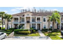 Well-maintained condo with a tile roof, manicured landscaping, and reserved parking at 13801 Timberland Dr # 202, Orlando, FL 32824
