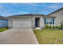 Charming single story home with a two car garage, manicured lawn, and blue shutters at 1750 Eagle Hammock Blvd, Eagle Lake, FL 33839