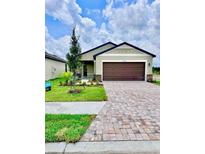 Beautiful one-story home featuring a lush lawn, brick paved driveway and a two car garage at 3219 Cup Dr, Lakeland, FL 33803