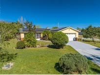 Charming yellow home with solar panels, landscaped yard and a long driveway at 401 Cart Ct, Kissimmee, FL 34759