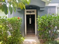 Charming entryway with dark wood door, a welcome mat and lush green landscaping, creating a warm invitation at 6640 S Goldenrod Rd # 118B, Orlando, FL 32822