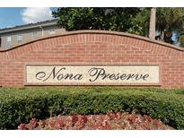 Nona Preserve brick community sign surrounded by vibrant green bushes and colorful flowers at 9575 Silver Buttonwood St, Orlando, FL 32832