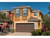 Two-story home featuring a two car garage, shuttered windows and small Juliette balconies at 9575 Silver Buttonwood St, Orlando, FL 32832