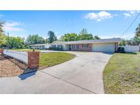 Charming single-story home with brick accents, a circular driveway, and a well-maintained front yard at 980 Oleander Se Dr, Winter Haven, FL 33880