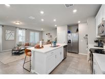 Bright, open-concept kitchen features a spacious island, stainless steel appliances, and seamless flow into the living area at 2052 Milkweed St, Ocoee, FL 34761