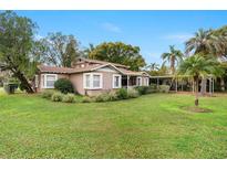 Charming home featuring lush landscaping, mature trees and a convenient covered carport at 26 Backspin Ln, Orlando, FL 32804