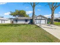Charming single-story home with a well-maintained lawn, two-car garage, and mature trees on a sunny day at 2801 W Covington Dr, Deltona, FL 32738
