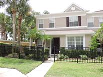 Charming two-story home with a well-manicured lawn, dark trim and lush palm trees at 4527 Sunset Ln, Oviedo, FL 32765