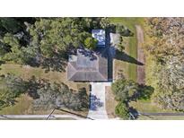 A stunning aerial view of a home with a long driveway, surrounded by lush trees on a spacious lot at 5150 Old Howell Branch Rd, Winter Park, FL 32792