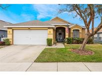 Charming single-story home with a well-manicured lawn and a two-car garage at 130 Bloomingdale Dr, Davenport, FL 33897