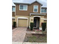 Charming townhome featuring a brick paved drive, attached garage, and a welcoming entryway at 1309 Heritage Commons Dr, Winter Springs, FL 32708