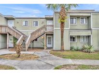 A charming townhouse with light green siding, wooden stairs, and a well-manicured lawn at 185 Scottsdale Sq # 185, Winter Park, FL 32792