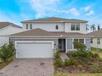 Beautiful two-story home features a brick driveway, two-car garage, and manicured landscaping at 2474 Southlawn Lane, Clermont, FL 34714