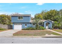 Charming home featuring a two-story design, a well-manicured lawn, and an attached garage at 2909 Depauw Ave, Orlando, FL 32804