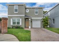 Charming home with a brick-paved driveway, well-maintained lawn, and an attached one-car garage at 5852 Mariposa Cove Ln, Orlando, FL 32822
