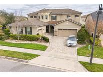 Stunning two-story home with a three-car garage and beautifully landscaped front yard at 619 Oxford Chase Dr, Winter Garden, FL 34787