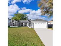 Charming single-story home featuring a well-maintained lawn, two-car garage, and inviting curb appeal at 738 Paris Dr, Kissimmee, FL 34759