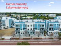 Modern townhome exterior boasting a corner lot with lake view, gray and blue color scheme and small, personal balcony at 871 City Walk Ln # B-1, Oviedo, FL 32765