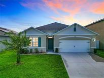 Charming single-story home featuring a well-maintained lawn and a welcoming facade with a two car garage at 1133 August Sky Dr, Deltona, FL 32738